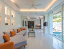 Modern living area with pool access, white walls, and orange accent pillows