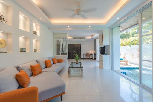 Modern living area with pool access, white walls, and orange accent pillows