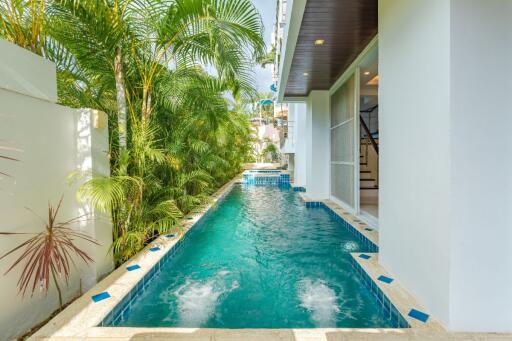 Outdoor swimming pool next to building and greenery