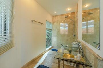 Modern bathroom with glass sink and rainfall shower