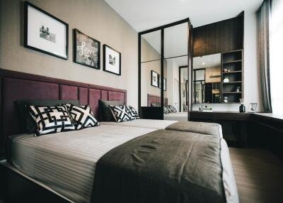 Spacious modern bedroom with a double bed, wall art, large mirror, and desk area