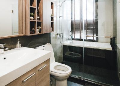 Modern bathroom with glass shower door and wooden cabinets