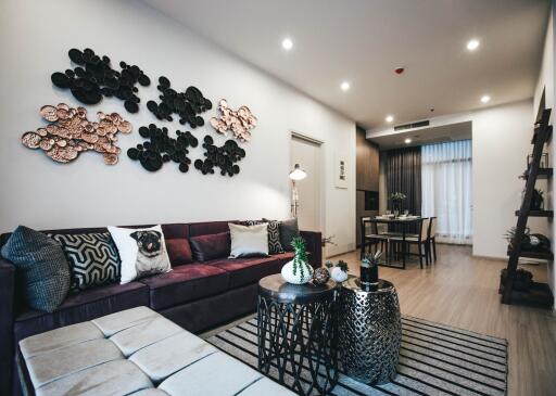 Modern living room with stylish decor, comfortable seating, open layout to dining area.