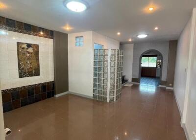 Spacious modern living area with tiled floor, recessed lighting, and decorative wall elements