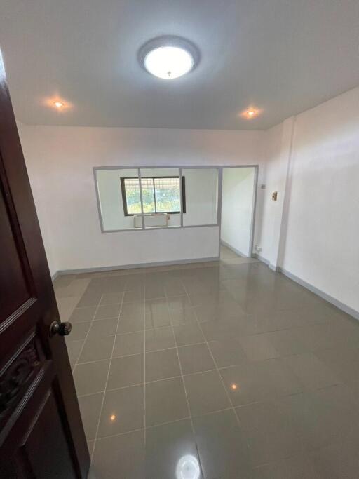 Spacious bedroom with tiled flooring and a large window