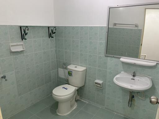 Clean bathroom with toilet, sink, and mirror