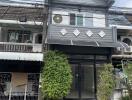 Exterior view of a townhouse with a small balcony and green plants near the entrance