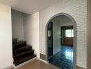 Entryway with stairs and arched doorway