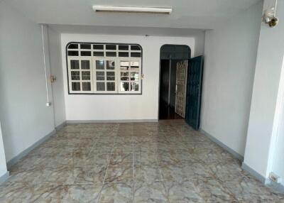 Empty living room with tiled floor and large window