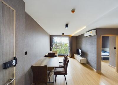 Modern living room with dining area and view of bedroom