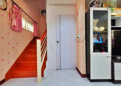 Bright living space with red stairway and storage cabinet