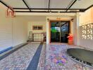 Outdoor covered space with tiled flooring and trampoline