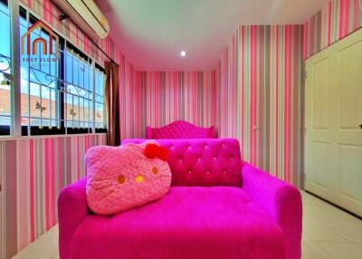 Colorful bedroom with pink decor and Hello Kitty pillow