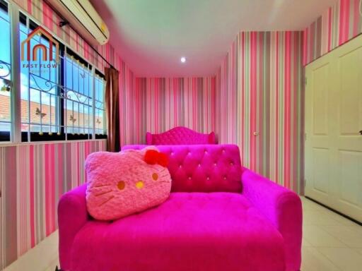 Colorful bedroom with pink decor and Hello Kitty pillow