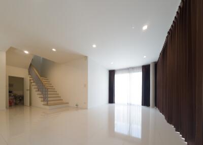 Spacious living room with large windows and staircase