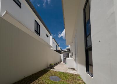 Narrow outdoor pathway between white modern buildings