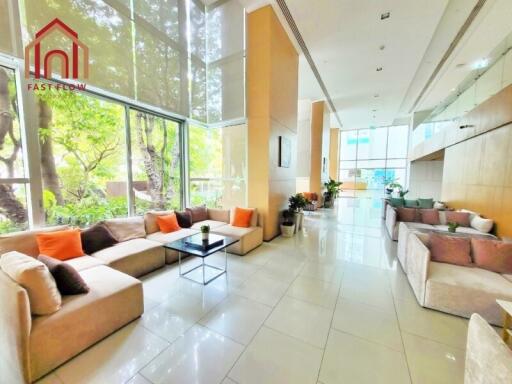 Spacious and bright living area with large windows and comfortable seating