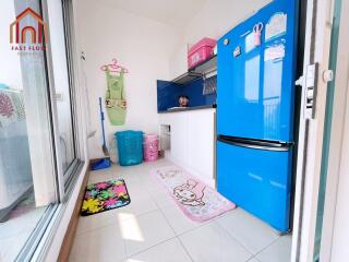 Modern kitchen with blue refrigerator and colorful floor mats