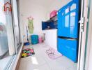 Modern kitchen with blue refrigerator and colorful floor mats