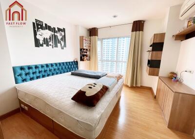 Spacious bedroom with a large bed, wooden floor, and modern decor