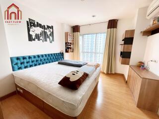 Spacious bedroom with a large bed, wooden floor, and modern decor