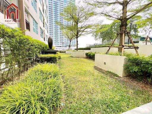 Lush garden area beside a modern building with trees