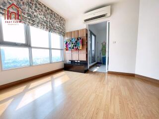 Bright and airy living room with wooden flooring, large windows, and modern decor