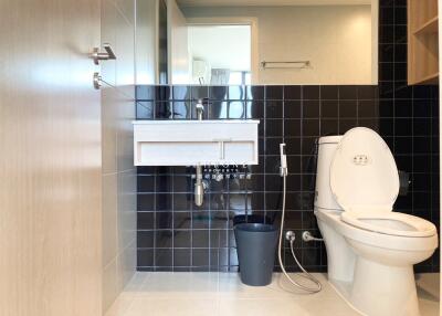 Modern bathroom with black tiles and white fixtures