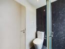 Modern bathroom with glass shower door and tiled walls