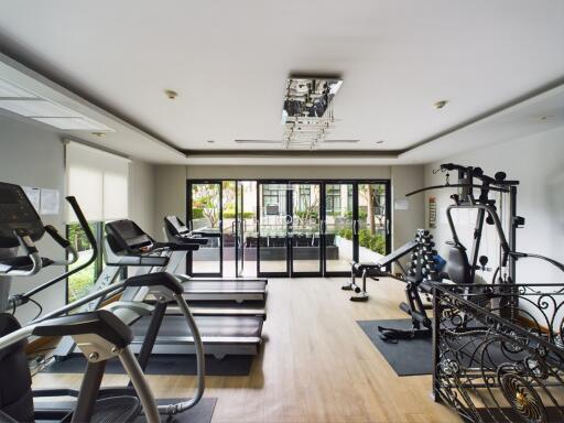 Modern gym with various exercise equipment and large windows