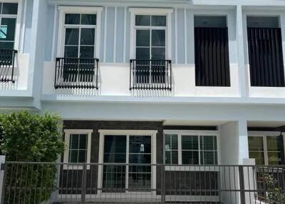 Front facade of a modern townhouse with a gated driveway