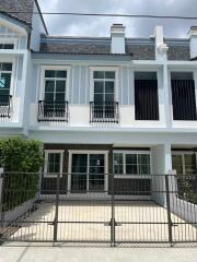 Front facade of a modern townhouse with a gated driveway