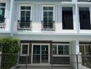 Front facade of a modern townhouse with a gated driveway