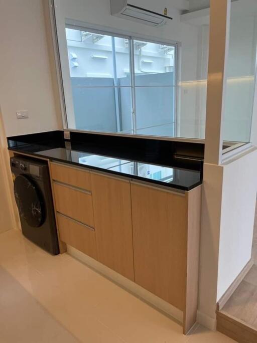 Modern kitchen with wooden cabinets and a built-in washer