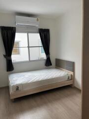 Small bedroom with single bed and air conditioner