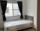 Small bedroom with single bed and air conditioner