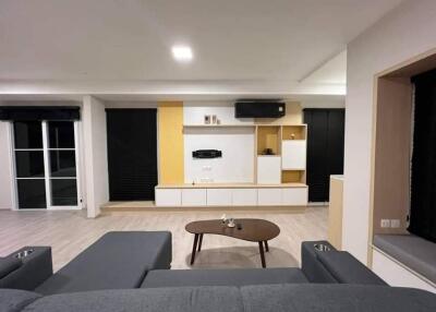 Modern living room with a gray couch, wooden coffee table, and built-in shelving unit