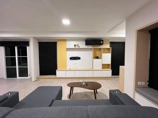 Modern living room with a gray couch, wooden coffee table, and built-in shelving unit