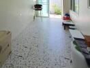 Long narrow room with terrazzo flooring and window