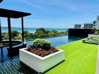 Rooftop pool with seating area and sea view