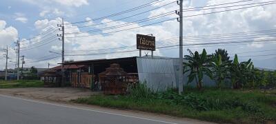 Roadside building with outdoor structures and banana plants