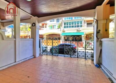 View of a covered balcony area with tiled flooring and metal gate