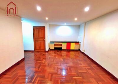 Bright and spacious living room with wooden flooring and colorful storage units