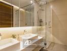 Modern bathroom with double sinks, large mirrors, and a walk-in shower