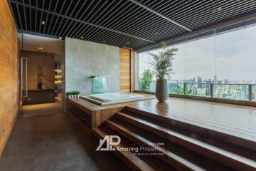 Modern spa area with city view, featuring a wooden deck and indoor jacuzzi