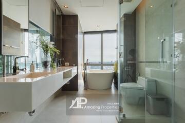 Modern bathroom with large windows, bathtub, and twin sinks