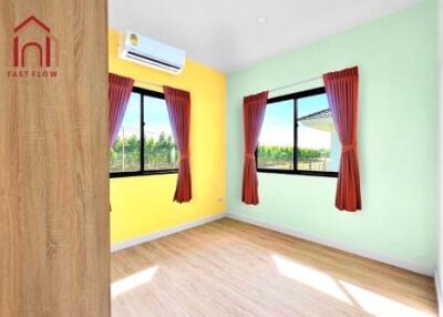 Sunny bedroom with colorful walls and wooden flooring