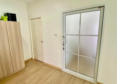 Bedroom with wooden floor, wardrobe, door, and large window