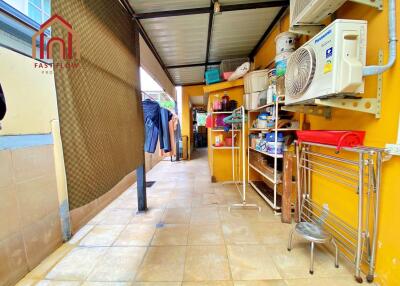 Covered utility area with storage shelves and household items