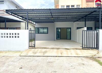 Entrance of a modern residential building with gated front porch and covered parking area